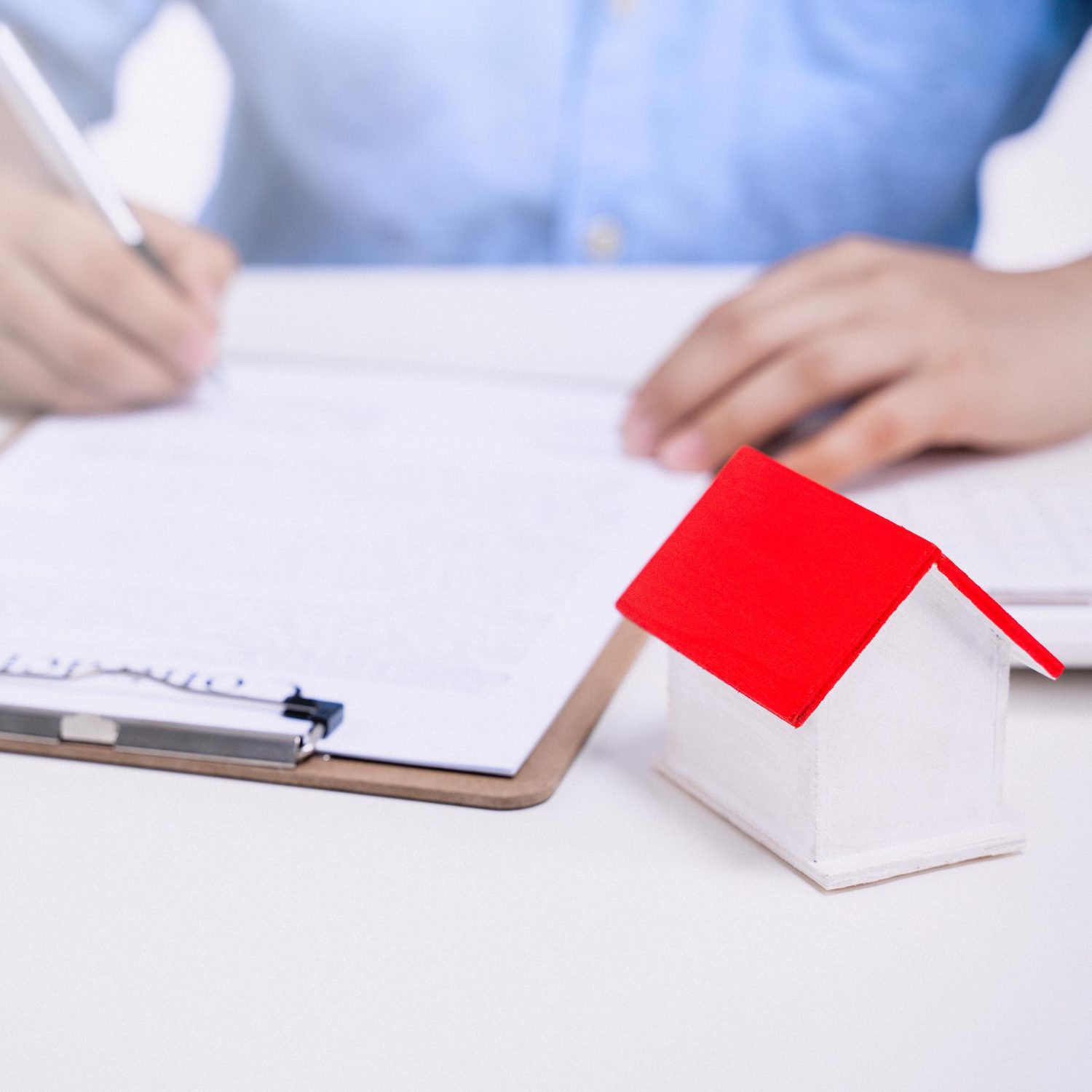 closeup shot of a person writing in a book with a gavel on the table