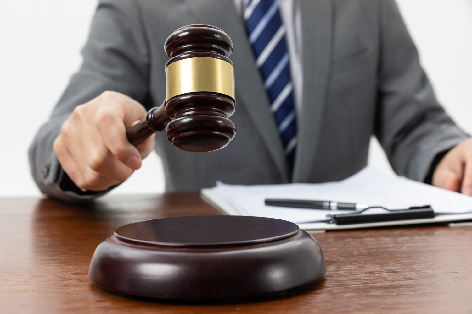 closeup shot of a person holding a gavel on the table